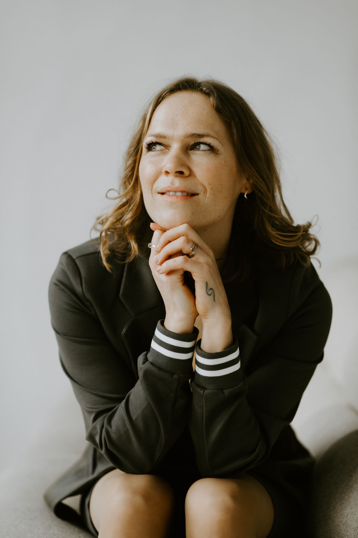 Raphaela Grollius sitzt nachdenklich mit dem Kinn auf den gefalteten Händen