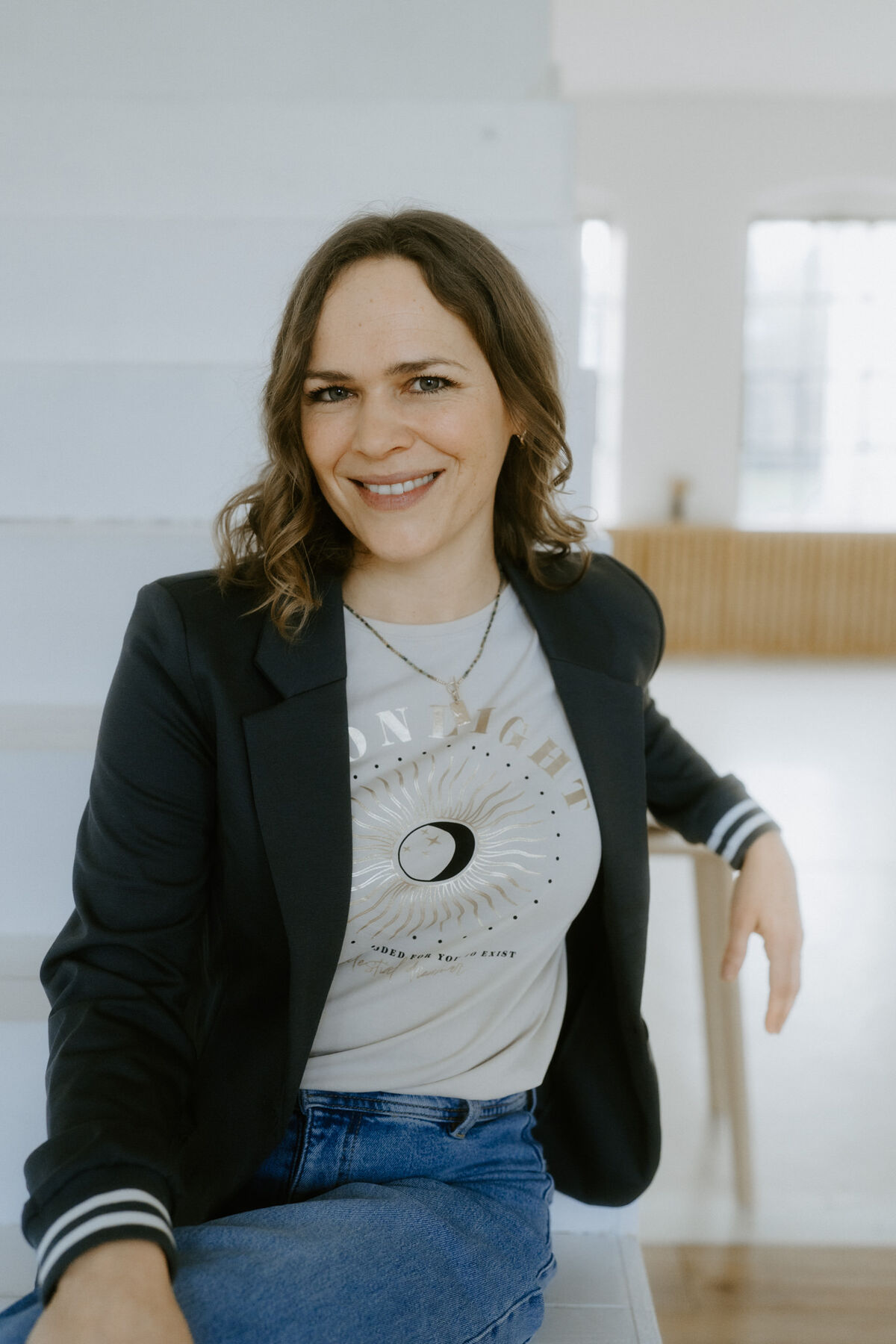Porträt von Raphaela Grollius, Mentalcoach aus Königswinter, lächelnd in einem hellen Loft